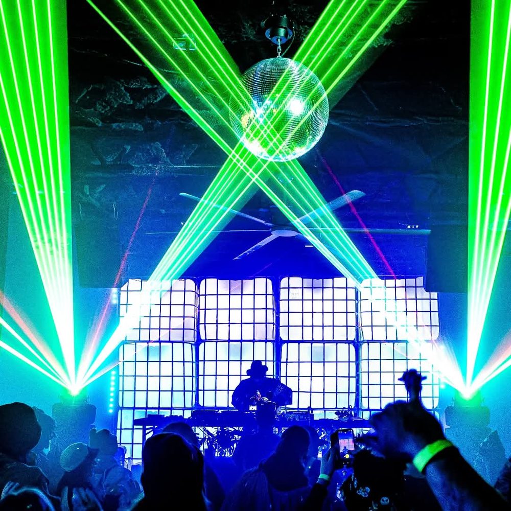 Green laser fan crossing over the booth