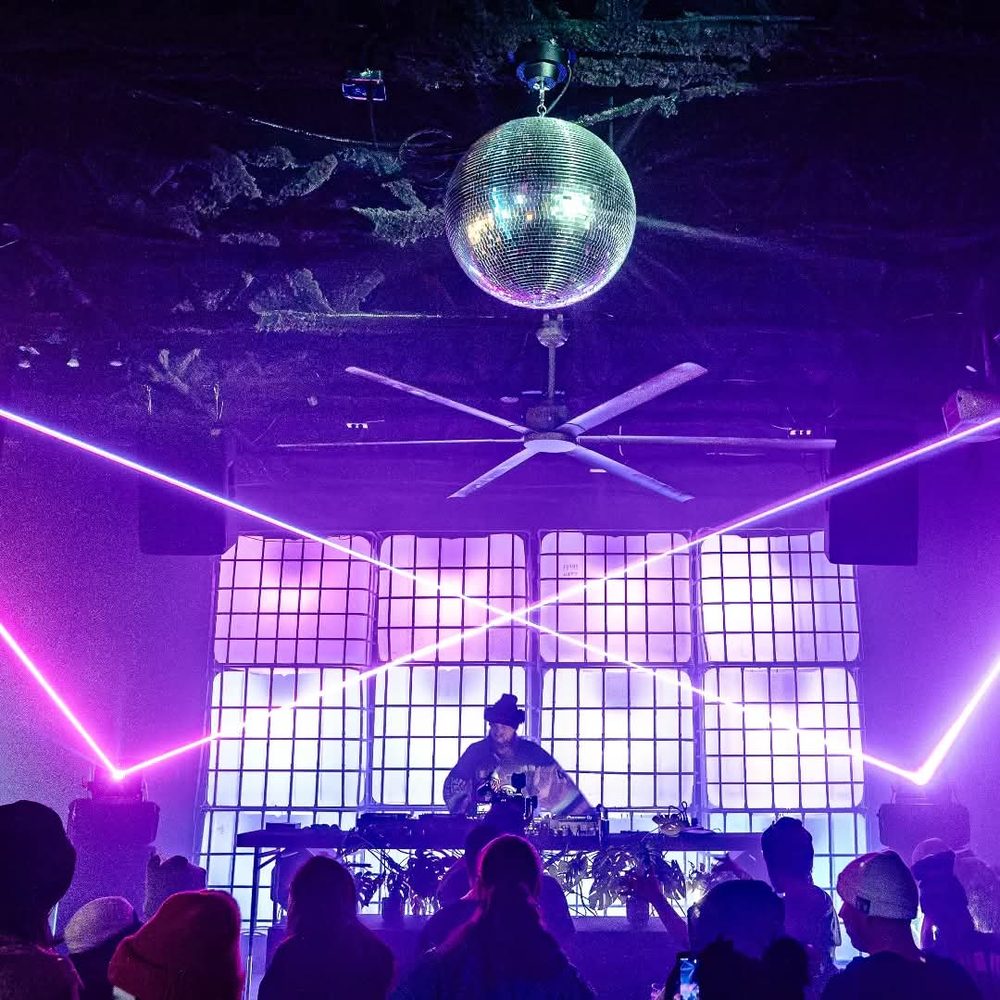 Purple laser lines crossing over the booth and disco ball